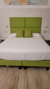 ein Bett mit einem grünen Kopfteil in einem Schlafzimmer in der Unterkunft Affittacamere 5 Terre Dolci Sogni in La Spezia