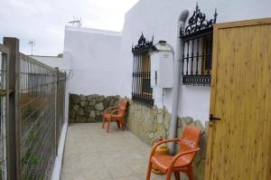 a patio with two chairs and a fence at Alojamiento el Chaparro Barbate junto a la venta el loro in Barbate