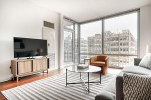 a living room with a tv and a couch and a table at South Loop 1br w gym lounge nr Grant Park CHI-850 in Chicago