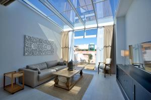 uma sala de estar com um sofá e uma mesa em El Armador Casa Palacio by Luxury Suites Cádiz em Cádiz