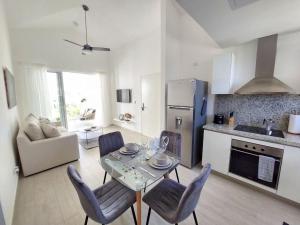 a kitchen and living room with a table and chairs at Cozy 1BDR with Pool Golf View in Hard Rock Golf in Punta Cana