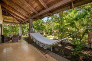 an outdoor porch with a hammock on a patio at Claudia Villagge in Guanacaste