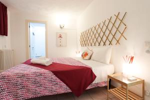 a bedroom with a bed with a red and white blanket at Bellavita BB in Anacapri
