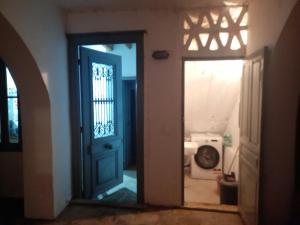 an open door to a room with a washing machine at Maison charmante in Hydra