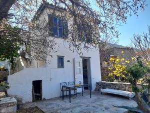 una casa blanca con una mesa delante en Maison charmante en Hydra