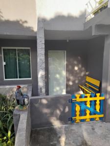 a bird sitting on a table in front of a house at Suíte do Galo in Arraial do Cabo +15 photos
