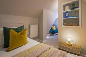Roseland Apartment 5 في أروندل: غرفة نوم بسرير ومخدة صفراء