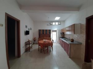 a kitchen with a table and chairs in a room at Appartamenti Vacanza al centro in Pantelleria +9 photos