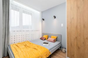 a small bedroom with a bed and a window at Mint Apartments Tychy in Tychy