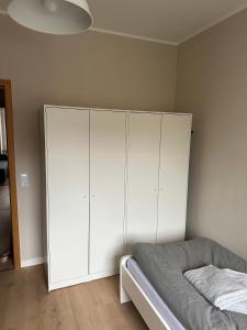a bedroom with a bed and a white cabinet at Nur ein Augenblick vom Weltkulturerbe entfernt! GE1L in Essen