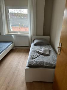 ein kleines Schlafzimmer mit einem Bett und einem Fenster in der Unterkunft Nur ein Augenblick vom Weltkulturerbe entfernt! GE1L in Essen