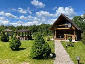 a log cabin in a field with trees in front at Rähni Guesthouse Lake Peipsi in Vilusi