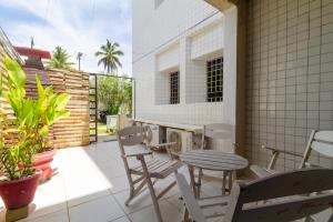 a patio with a table and chairs on a porch at Apt/Cas Porto de Galinhas in Porto De Galinhas