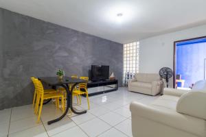 a living room with a table and yellow chairs at Apt/Cas Porto de Galinhas in Porto De Galinhas
