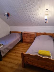 a bedroom with two beds and a wooden floor at Rähni Guesthouse Lake Peipsi in Vilusi