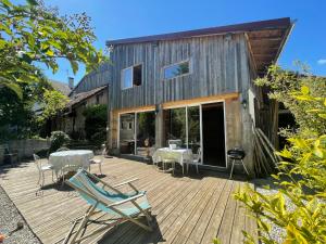 um deque de madeira com cadeiras e mesas numa casa em grande demeure d'exception em Clairvaux-les-Lacs