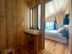 uma casa de banho com um lavatório e uma cama num quarto em grande demeure d'exception em Clairvaux-les-Lacs