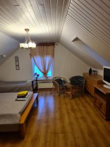 uma sala de estar com uma cama, uma mesa e cadeiras em Rähni Guesthouse Lake Peipsi em Vilusi