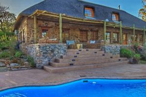 una casa de piedra con una piscina frente a ella en Stone House McGregor, en McGregor