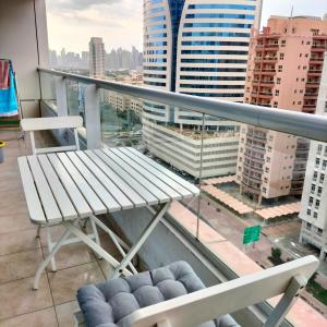 a bench on a balcony with a view of a city at Amazing apartment 2 bed rooms in Tecom 6 pax in Dubai