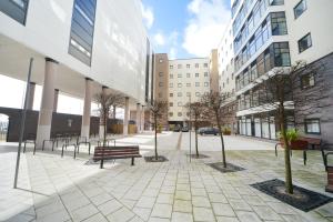 a courtyard with benches and trees in front of buildings at Newport Student Village (Campus Accommodation) in Newport