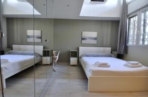 a bedroom with two beds and a glass wall at [Luxury apartment near Niguarda] Graziano39 in Milan