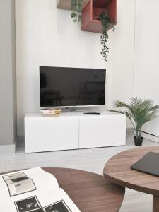 a living room with a large television on a white cabinet at [Luxury apartment near Niguarda] Graziano39 in Milan