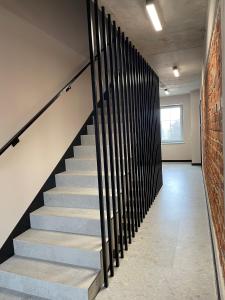 a staircase with black railings in a room with a brick wall at THE HOUSE near Lake & Old Town in Olsztyn