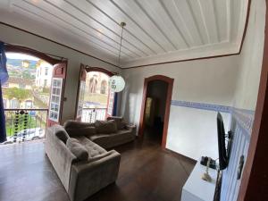 uma sala de estar com dois sofás e uma grande janela em República Birinaite em Ouro Preto