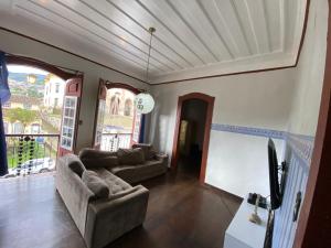a living room with two couches and a large window at República Estudantil Birinaite in Ouro Preto