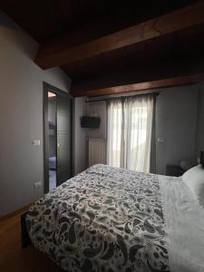 1 dormitorio con cama con edredón y ventana en La Dolce Vita, en Bovino