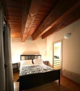 1 dormitorio con cama y techo de madera en La Dolce Vita, en Bovino