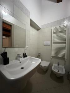 Baño blanco con lavabo y aseo en La Dolce Vita, en Bovino