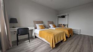 a bedroom with two beds and a desk and a chair at Maia Apartment in Maia