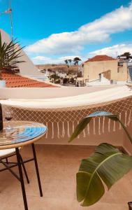 un balcón con una mesa y una tabla de surf en la pared en Gaia Luxury Rooms en Rethymno