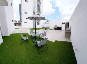 un patio con una mesa con sillas y una sombrilla en Departamento Exclusivo, High Apartment with Great Location 4-B en Matamoros