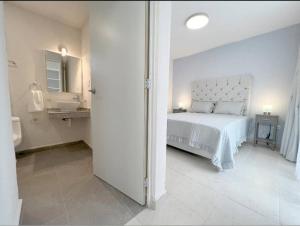 biała sypialnia z łóżkiem i umywalką w obiekcie Departamento Exclusivo, High Apartment with Great Location 4-B w mieście Matamoros