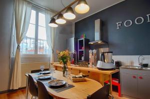 une cuisine avec une table en bois et des chaises ainsi qu'une salle à manger dans l'établissement Sweet Nina Jazz- Appartement Cosy de 70 M2 Hyper Centre, au Mans