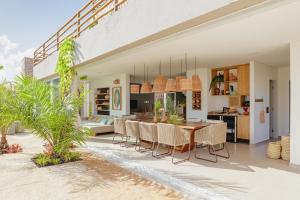 a dining room and kitchen of a house on the beach at VILA PITHAYA - Casa Pithaya in Japaratinga