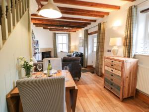 a living room with a wooden table and chairs at Corner Cottage in Staindrop