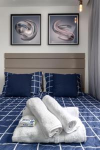 Una cama azul con toallas encima. en Apartamento 2 quartos a 4 minutos do Rio centro e jeunesse arena na barra da Tijuca, en Río de Janeiro