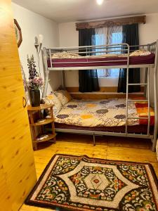 a room with two bunk beds and a rug at Cabana Huta Sinteu in Şinteu
