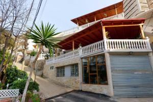 a building with a garage door and a balcony at Vila Jon'a in Sarandë