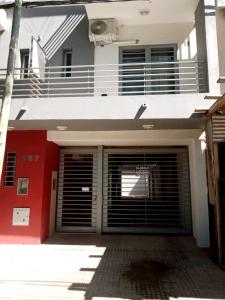 un edificio rojo y blanco con garaje con puerta en Monoambiente céntrico La Plata en La Plata