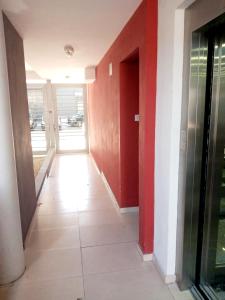 un pasillo vacío con paredes rojas y suelo de baldosa en Monoambiente céntrico La Plata en La Plata