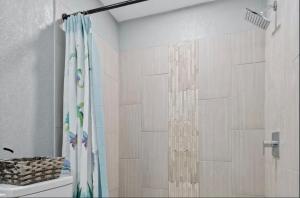 a bathroom with a shower with a shower curtain at Clearwater Charm in Clearwater +13 photos