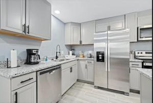 a kitchen with white cabinets and stainless steel appliances at Clearwater Charm in Clearwater