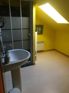 a bathroom with a sink and a room with yellow walls at Peaceful, comfortable retreat with pool in Montcléra