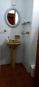 y baño con lavabo y espejo. en Departamento Céntrico 2 dormitorios en San Miguel de Tucumán