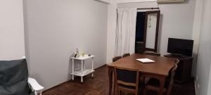 Habitación con mesa con sillas y TV. en Departamento Céntrico 2 dormitorios en San Miguel de Tucumán